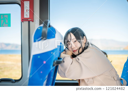 年輕女子搭乘公車,看著窗外 年輕女子搭乘公車,看著窗外 121024482