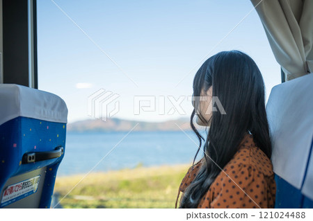 Young woman on a bus looking out the window Young woman on a bus looking out the window 121024488