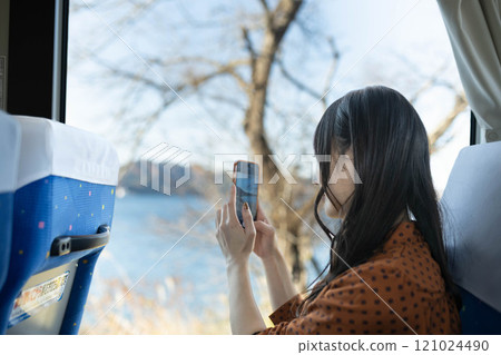 Young woman on a bus looking out the window Young woman on a bus looking out the window 121024490