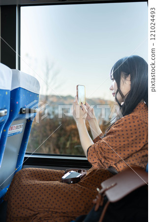Young woman on a bus looking out the window 121024493