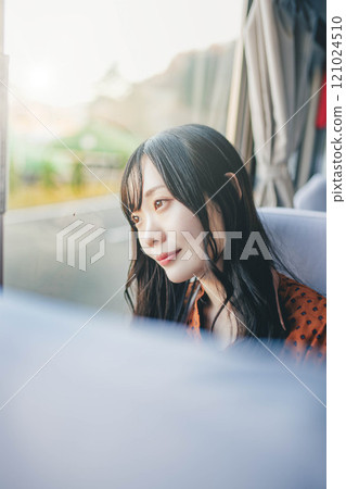 年輕女子搭乘公車,看著窗外 年輕女子搭乘公車,看著窗外 121024510