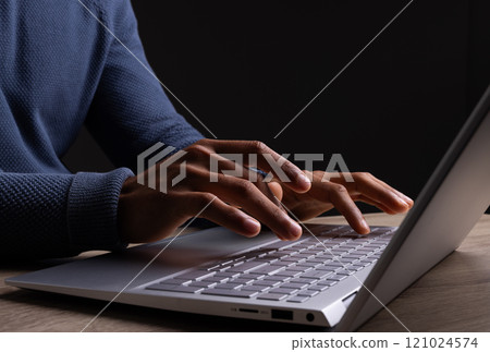 Biracial businessman using laptop with copy space on black background Biracial businessman using laptop with copy space on black background 121024574