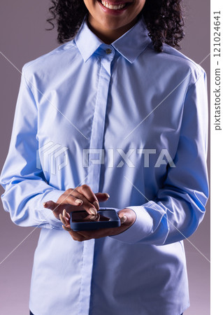 Vertical image of biracial businesswoman using smartphone with copy space on grey background 121024641