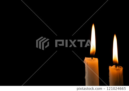 Two lit white candles with copy space on black background 121024665