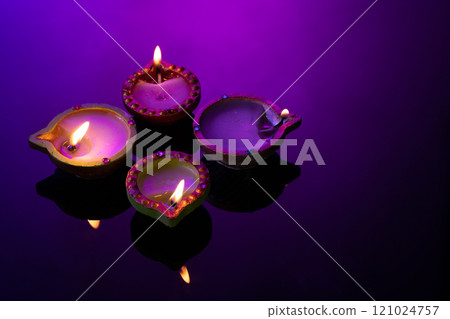Close up of four diwali candles with copy space on purple background 121024757