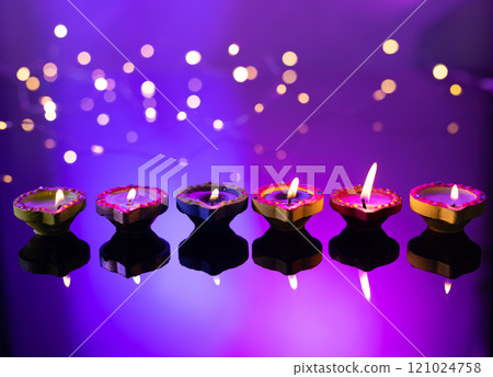 Close up of six diwali candles with copy space on purple background Close up of six diwali candles with copy space on purple background 121024758