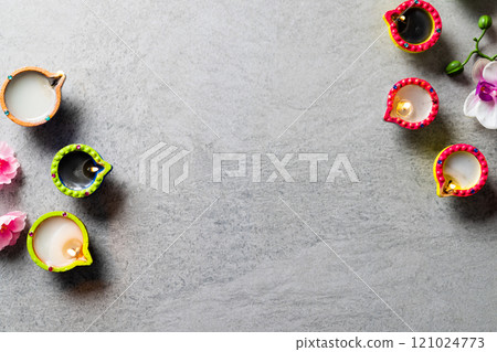 Close up of diwali candles and flowers with copy space on grey background 121024773