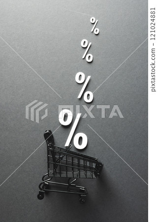 Shopping trolley and white percent signs with copy space on grey background 121024881