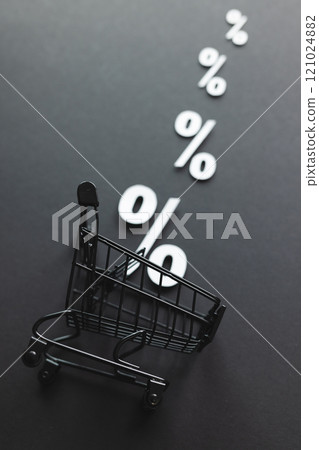 Shopping trolley and white percent signs with copy space on grey background 121024882