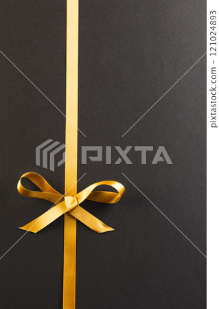 Gold gift ribbon and bow with copy space on black background Gold gift ribbon and bow with copy space on black background 121024893
