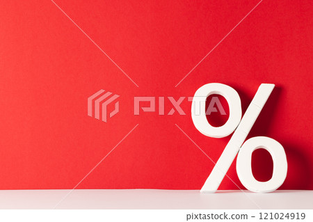 White percent sign with copy space against red background White percent sign with copy space against red background 121024919