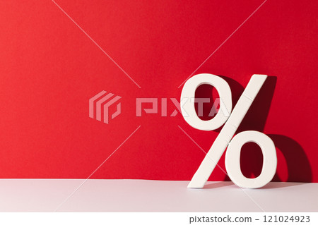 White percent sign with copy space against red background White percent sign with copy space against red background 121024923