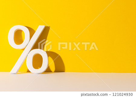 White percent sign with copy space against yellow background White percent sign with copy space against yellow background 121024930