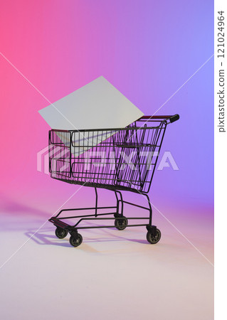 Vertical image of shopping trolley with blank canvas and copy space over neon purple background Vertical image of shopping trolley with blank canvas and copy space over neon purple background 121024964
