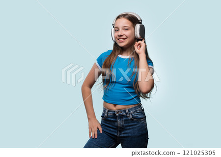 Girl with long hair smiling while wearing headphones. 121025305