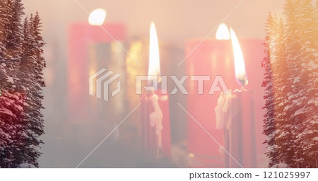 Image of candles over winter coniferous trees with snow Image of candles over winter coniferous trees with snow 121025997