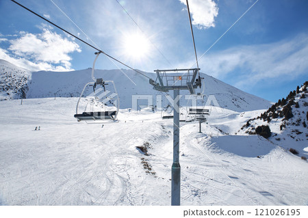 Chunkurchak ski resort. Empty ski lift seats. Mountain slope at sunny winter day Chunkurchak ski resort. Empty ski lift seats. Mountain slope at sunny winter day 121026195