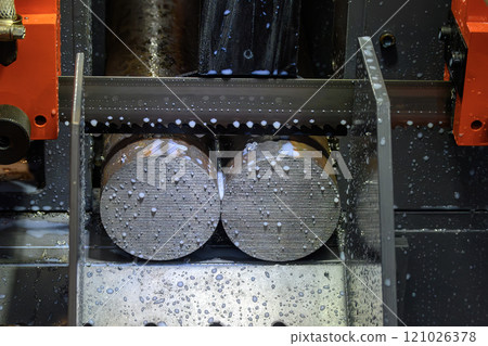 The band saw cutting machine cut the group metal shaft parts with liquid coolant method. 121026378