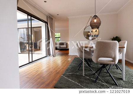 Modern dining room with elegant decor and cozy seating, sunlight streaming in, at home Modern dining room with elegant decor and cozy seating, sunlight streaming in, at home 121027019