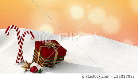 Image of presents and christmas candies lying on snow with yellow lights falling in background 121027052