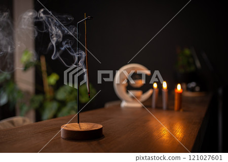 incense stick smokes on a wooden stand on a dark background. Aromatherapy, Smoke while burning incense. smoke for prayers and meditation. prayer to buddha. incense for relaxation and yoga 121027601
