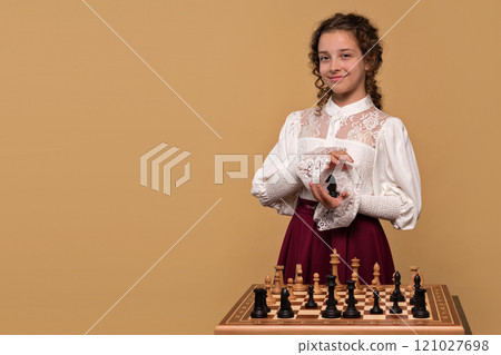 Young girl holding black chess knight 121027698