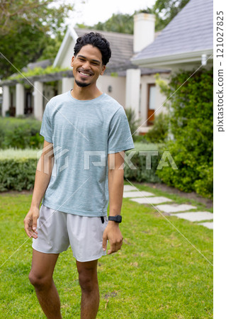Smiling young man enjoying sunny day outdoors in casual outfit 121027825
