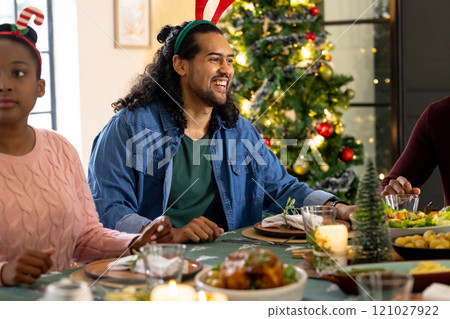 Multiracial friends celebrating christmas together with holiday meal, at home 121027922