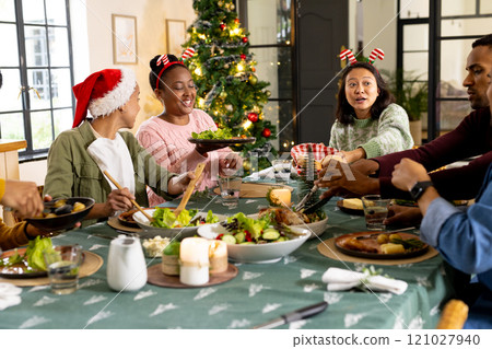 Gathered for christmas dinner, multiracial friends, at home 121027940