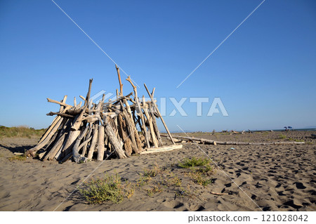 Washed up wood used to build wooden shelters against wind and sun on the beach near Marina di Grosseto, Tuscany, Italy Washed up wood used to build wooden shelters against wind and sun on the beach near Marina di Grosseto, Tuscany, Italy 121028042