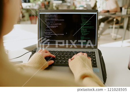 Medium close up of unrecognizable woman programming on laptop in office during work day 121028505