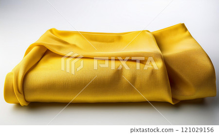A yellow blanket is folded and laying on a white surface 121029156