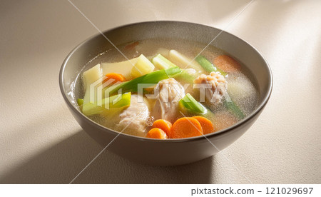 A bowl of soup with vegetables and chicken 121029697