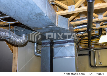Interior space features extensive metal ductwork, piping installed in basement layout demonstrates careful planning for ventilation, airflow, emphasizing industrial design. 121029871