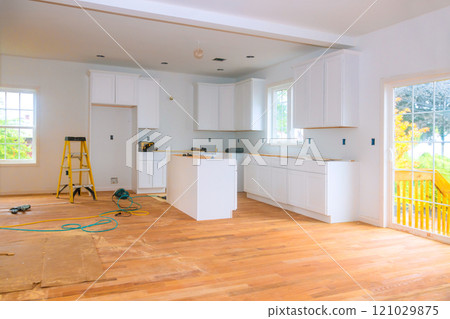 Bright, airy kitchen features new white cabinets hardwood flooring as renovations are underway during construction Bright, airy kitchen features new white cabinets hardwood flooring as renovations are underway during construction 121029875