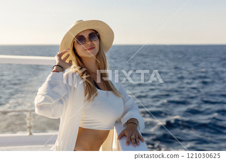 Elegant sexy woman in white dress standing near railings and looking on sunset. Like yacht style. Elegant sexy woman in white dress standing near railings and looking on sunset. Like yacht style. 121030625