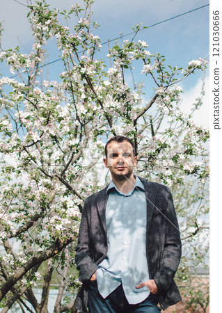 portrait of  man in a jacket and shirt in apple blossom 121030666