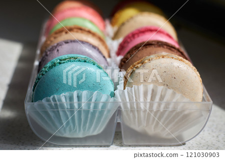 Bright colorful cakes French Macarons with white paperpan in plastic box 121030903