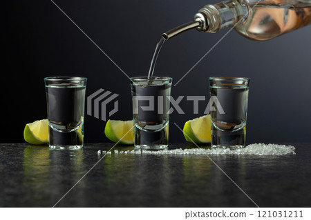 Tequila with lime and salt on a stone table. Tequila with lime and salt on a stone table. 121031211