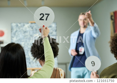 Young woman taking part in bidding Young woman taking part in bidding 121031750