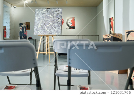 Easel with artwork in gallery hall 121031766