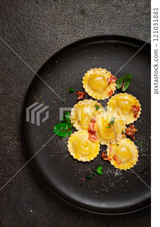 fresh ravioli, with butter, spices and herbs, fried bacon, on a black plate, top view, dark background, no people, fresh ravioli, with butter, spices and herbs, fried bacon, on a black plate, top view, dark background, no people, 121031881