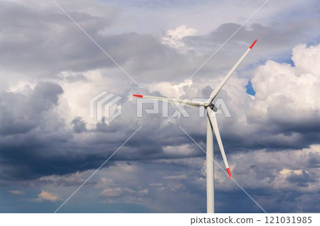 White wind turbine power station, copy space on cloudy sky, sustainable renewable electricity concept 121031985
