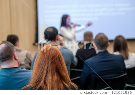 Audience listening to speaker at business presentation in conference room 121031986