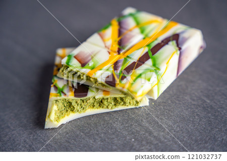 Trend Dubai white chocolate with pistachio paste and kataifi dough. Confectionery handmade sweets at home in the kitchen.  121032737