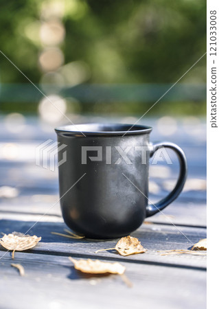 Cup of hot drink on nature background. Morning in the forest in nature with a hot drink 121033008