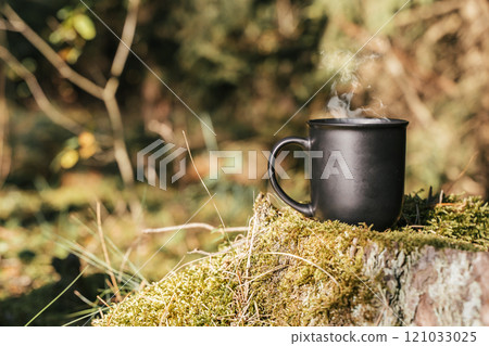 Cup of hot drink in the forest, in nature. 121033025