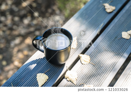 Cup of hot drink on nature background. Morning in the forest in nature with a hot drink 121033026