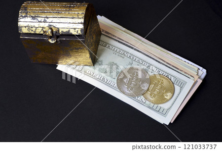 bitcoin coin and a chest next to a pack of dollars on a black background 121033737