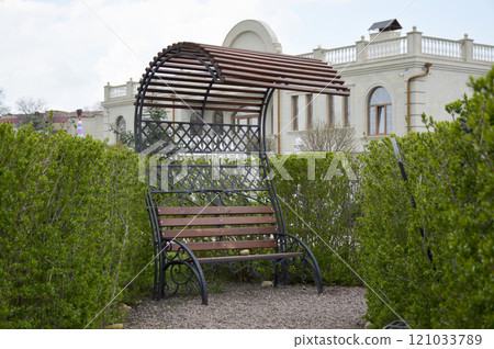 wooden bench with a canopy roof in a city park 121033789